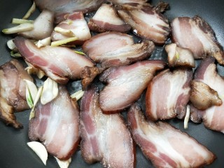 11、一菜二吃-豉椒芹菜炒腊肉,把腊肉片放入锅中。