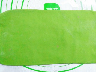 14、花样蒸饺系列(1),把绿色面团用擀面杖擀成长方形的面皮!在上面刷点水!