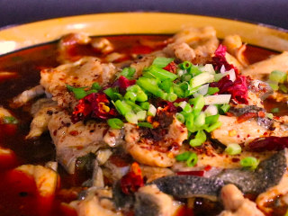 15、川妹子手把手教你做麻辣鲜香味美料足的水煮鱼,另起锅热油，将油加热至冒烟后淋入鱼碗中即可。