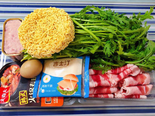 1、部队火锅,准备原材料羊肉片、茼蒿、辛拉面、午餐肉、鸡蛋、韩式火锅甜辣酱、吉士汀