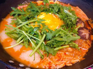 10、部队火锅,为了添加点绿色茼蒿切成小段放入中间微微小火煮一分钟最后加盐和味精调味均匀即可出锅享用