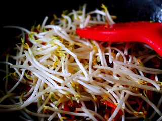 11、薄如蝉翼的春饼,加入摘洗干净的绿豆芽，这个时候需要大火爆炒一下，好锁住绿豆芽的水分（小编加了海天豆瓣酱以后，别的调料小编就没加，我觉得咸淡合适了，喜欢重口味的亲们可以再加点盐哈）；