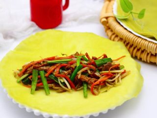 21、薄如蝉翼的春饼,把揭开的春饼平铺在盘子里，放入适量提前炒制好的馅料