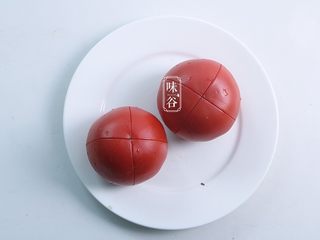 3、番茄牛肉煲,另取两个番茄用刀在上面切十字;