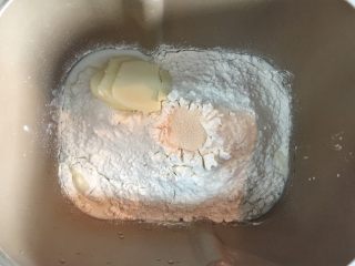 1、圣诞老人面包, 把主料依次投入面包机。先加液体原料牛奶和蛋液，再在两个角落分别放盐和糖，继续倒入高筋粉，在面粉上挖个坑投入酵母。这次不用后油法，直接和黄油