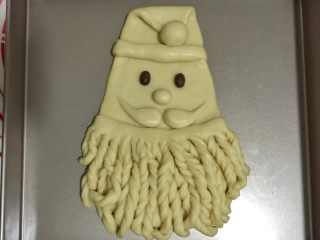 12、圣诞老人面包,如图安放在主面团上，帽沿两头收到面团后面。