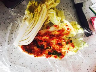 4、韩式辣白菜,拿出刚抹过盐的白菜（因为盐的作用白菜变的很软而且留下很多水，）用跟刚才抹盐的方法来把做好的酱料一层一层的抹到白菜叶之间。
