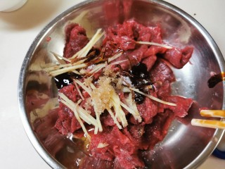 3、广式煲仔饭,牛肉片放调料捞均匀。