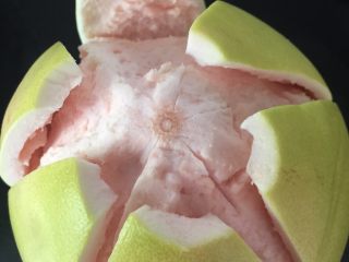 2、清火润肺蜂蜜柚子酱,用刀尖插入柚子皮，深度约1cm左右，从顶部到底部将柚子皮分割成6～8块，然后剥下外皮； 