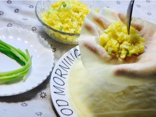 25、福袋黄金饭,葱段提前用热水烫软（打结用）拿出一张面皮，放上一勺黄金饭！