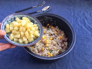 19、土豆腊肉焖饭,倒入刚才炸好的土豆丁，一起搅拌均匀，这一步可以在锅里翻炒均匀，心里只想着把照片拍得漂亮一些，竟然忘记了????