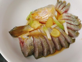 3、#咸味#黄花鱼版--孔雀开屏鱼,把处理好的放入碗内，加入葱姜段，料酒拌匀，腌制20分钟