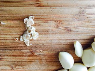 11、红烧小龙虾,大蒜根部切掉。因为想要完整的大蒜，我没有用刀背拍一下，刀背拍，剥起来方便。我这里只是一个个去皮。