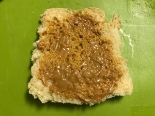 5、爱心早餐三明治,取一片吐司，我提起去掉硬边了，抹上花生酱。