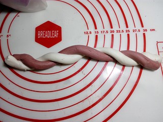 8、#欢度元宵#雨花石汤圆,把白色和红色面条卷在一起，成麻花状。