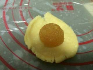 12、凤梨酥『简单版』,把馅分成每个都是15克的圆,酥皮也分成每个是15克的圆。『将酥皮按扁,包裹一个内馅。』