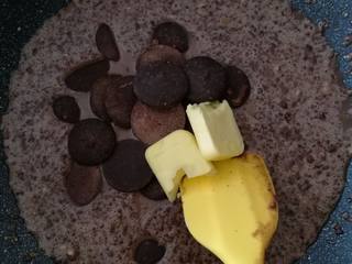 7、巧克力月饼（超详细）,将搅拌好的面糊倒入不粘锅中，一定要不粘锅。加入黄油和巧克力币，加小火翻炒。