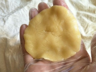 19、中式点心#潮汕腐乳饼#,面皮压扁加入1勺(约15克)馅料(时间匆忙我就直接用勺子,你们也可以先把馅料平均揉成15克的小圆),喜欢馅料多的也可以添加到20克