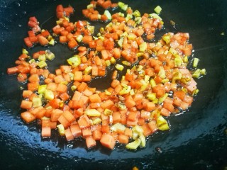 5、无敌好吃却不正宗的扬州炒饭,炒锅中热点油，大蒜炒香，先后倒入墨鱼、香肠粒炒香盛出待用。