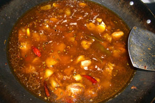 7、泉水鸡,炒至鸡块变深发黄，加入豆瓣、豆豉、泡椒、姜、蒜、干辣椒翻炒一下，倒入矿泉水和白糖煮。