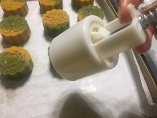 9、双色桃山皮月饼,食指和中指把模具的弹簧往回拉，月饼就会自己脱膜，动作同样轻一点慢一点。
