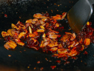 2、麻辣香锅,热锅中倒入香料油(香料油是油加八角、花椒、茴香、月桂叶等香料煸过的)，中小火加热，加入火锅底料、豆瓣酱、姜片、大蒜和葱段煸炒。