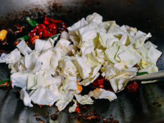 4、麻辣香锅,加入干辣椒、红葱头和包菜，炒2分钟。