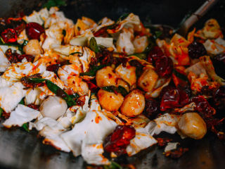 5、麻辣香锅,加入鱼丸、其他的蔬菜翻炒，加入米酒和白糖。