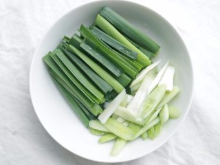 2、川味回锅肉,蒜洗净，蒜白斜刀切，蒜青直刀切；