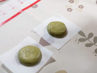 13、黑芝麻卡通汤圆,分成10克一份的面团，捏成面饼，包上馅料，压成饼状。下面垫上油纸。