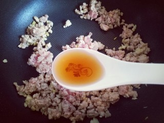 12、肉末茄子,炒至肉末发白时加入一勺料酒。