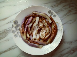 18、肉末茄子,把蒸熟的茄子摆放在盘子里。