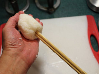 2、烤米卷,准备一杯盐水，将手沾湿后，取适当大小捣好尚热的米饭，揉成圆饭团，将竹棍或竹筷插入饭团。