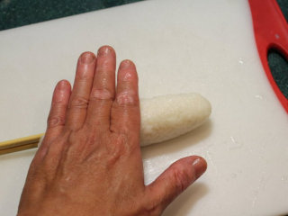 4、烤米卷,将饭条放于钻板上，用手掌滚压成结实长条型。