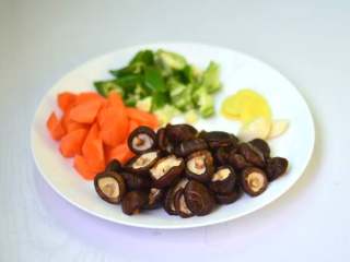 3、胡萝卜香菇炖鸡,香菇用温水泡软后冲洗干净捞出，胡萝卜、青椒切块，姜切片，蒜剥去外皮