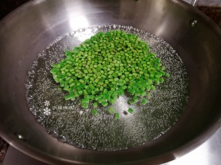 3、豇豆炒鸡蛋,锅里烧水放入豇豆颗粒煮1-2分钟后捞出沥干水分备用。