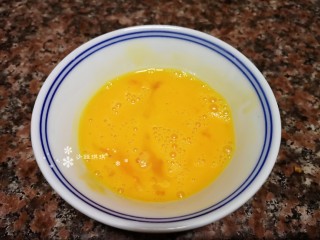 5、豇豆炒鸡蛋,将鸡蛋打入碗中，加入适量盐和料酒搅匀备用。