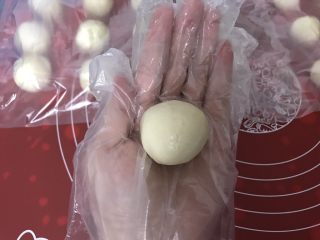 5、玫瑰鲜花饼,取一个水油皮，压扁，包上油酥，包的方法用左手虎口慢慢将油皮向上推，右手拇指将油酥往下推，包住油酥。捏紧封口，封口朝下摆好，依次做好16个