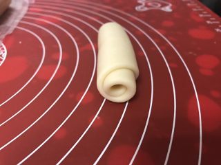 7、玫瑰鲜花饼,由上向下轻轻卷起，收口向下，依次做好剩下的，收口向下摆好，盖上保鲜膜静置15-20分钟。