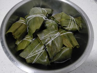 8、糯米蜜枣、桂圆、葡萄干粽子,再放入糯米，糯米馅8分满，先把前面往后叠，再把左、右往内叠，最后朝下叠，用线绳缠绕系住。