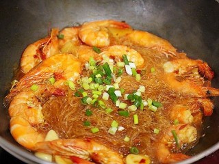 9、鲜虾粉丝煲,等到锅里的汤汁收的差不多的时候，关火，然后撒上少许香葱末，翻炒均匀。