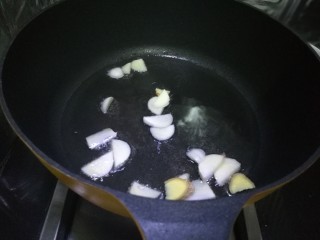 4、毛豆米炒肉丁,做坐锅上油放入蒜片和几片姜爆香