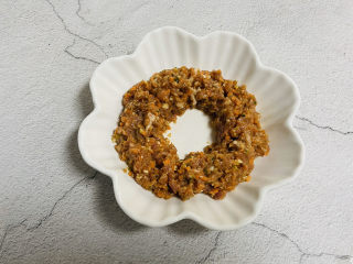 23、冬至美食+胡萝卜肉末蒸蛋,取一个漂亮的盘子把肉末倒入盘里，中间留一个空隙