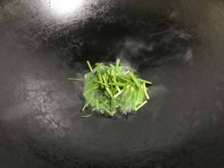 4、葱油拌面,把香葱放入锅中。