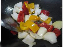 6、酸甜咕咾肉,將〔酱料〕中所有的材料混合均勻。取出多餘的油,放入洋葱及甜椒炒香