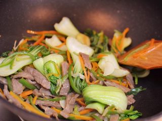 12、牛肉炒乌冬面,混合翻炒至菜叶变软。