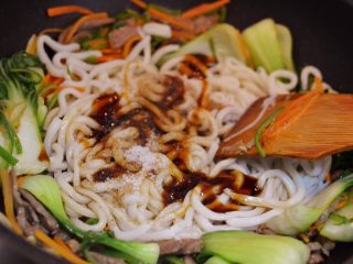 13、牛肉炒乌冬面,放入乌冬面、耗油、生抽、老抽、黑胡椒粉和盐。