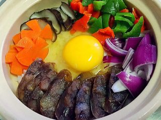 16、腊肠煲仔饭,打入鸡蛋。