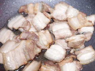 9、川味回锅肉,倒入2勺花生油，热油至5成，倒入切好的肉片，翻炒至肉片透明；