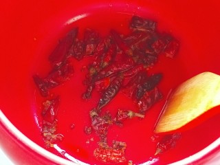 8、砂锅水煮肉片,砂锅里面放入适量花生油，把干辣椒，花椒放入里面，小火慢慢炒香捞出。(注意，这个步骤只有可以干烧的砂锅才能这样操作，我用的是干烧急冷都不破的坤博砂锅，所以这样操作没问题 )